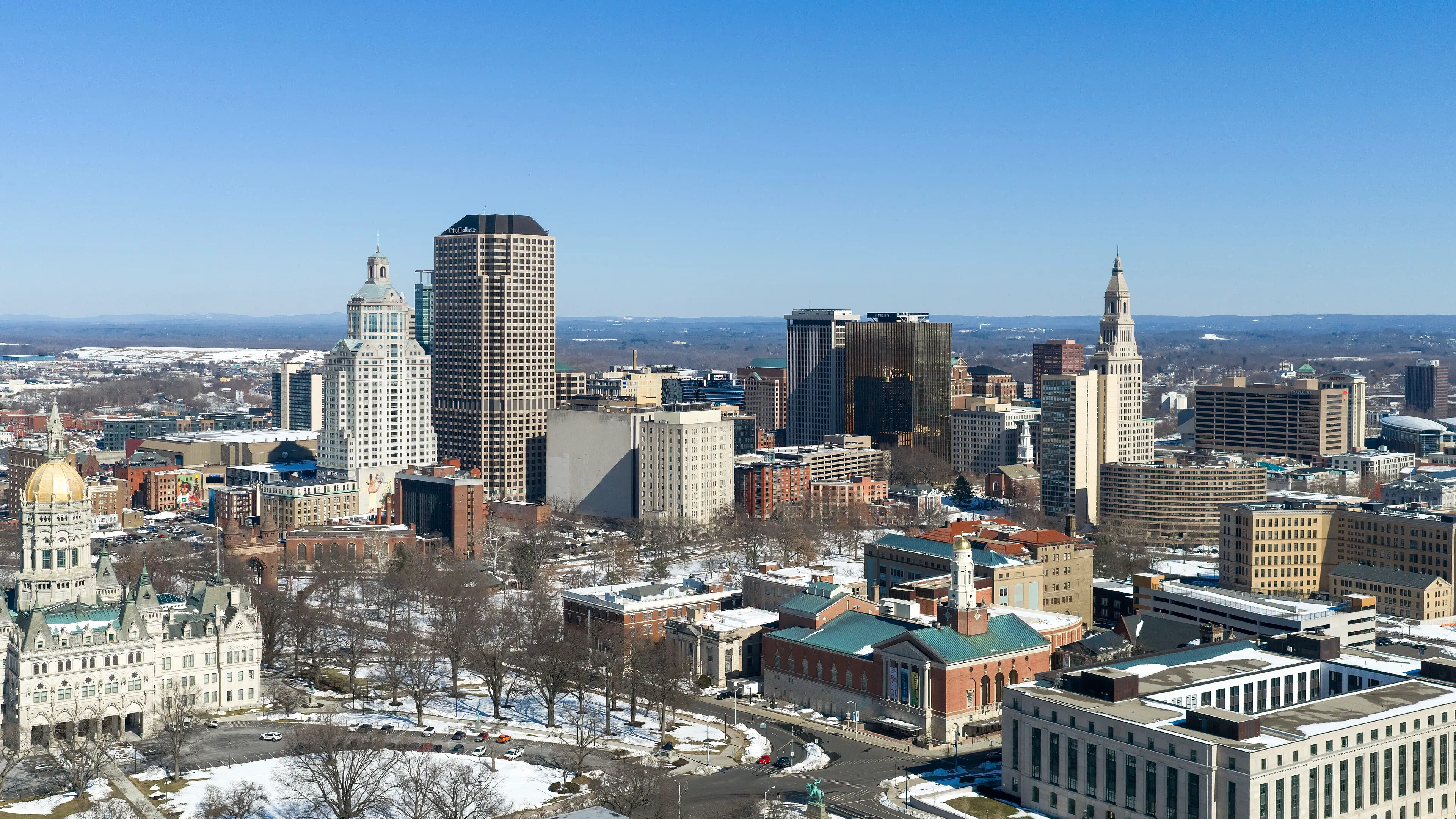 Aerial view of the Hartford, Connecticut skyline showing the city's downtown skyscrapers along the Connecticut River under clear skies