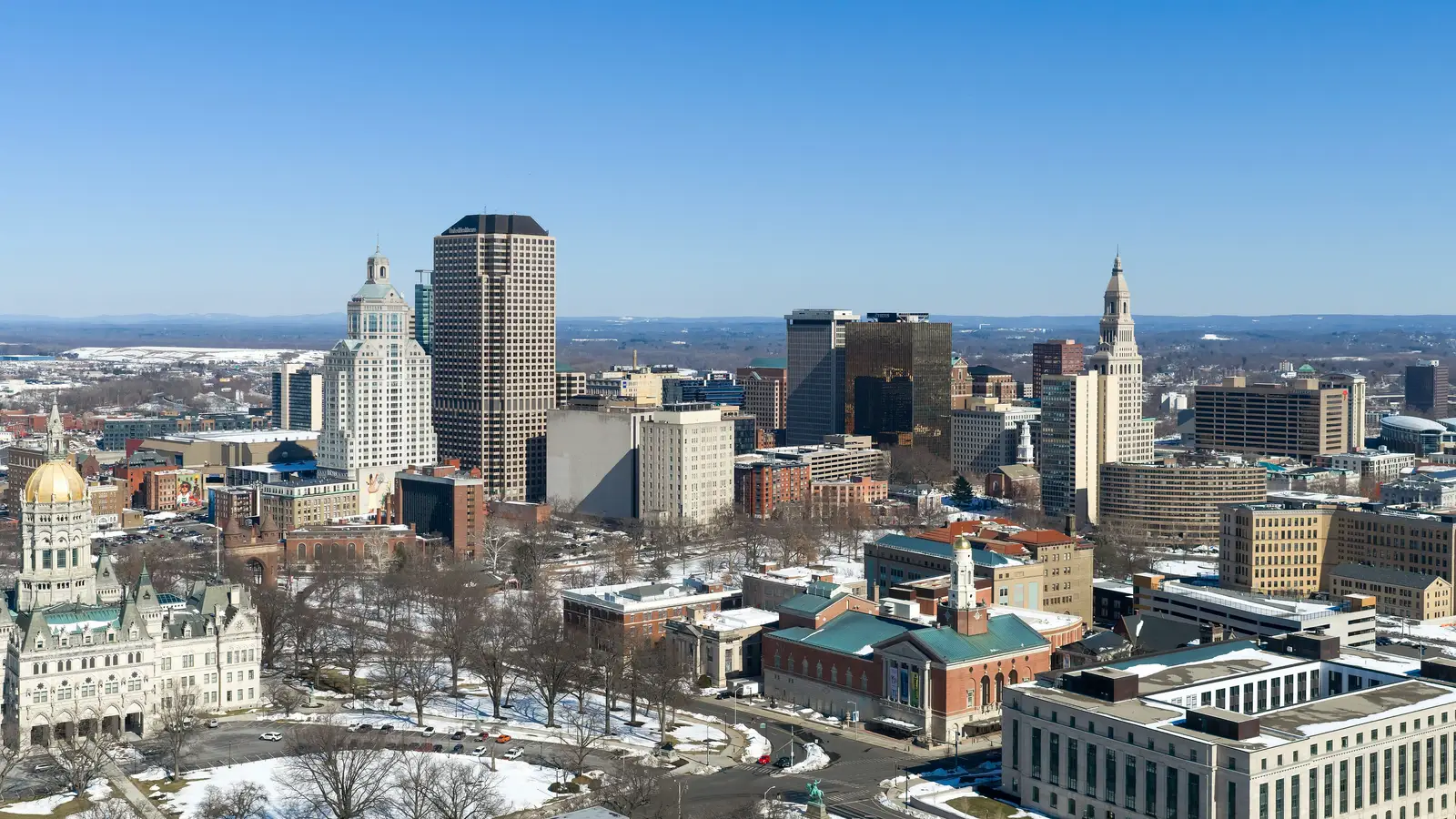 Aerial view of the Hartford, Connecticut skyline showing the city's downtown skyscrapers along the Connecticut River under clear skies