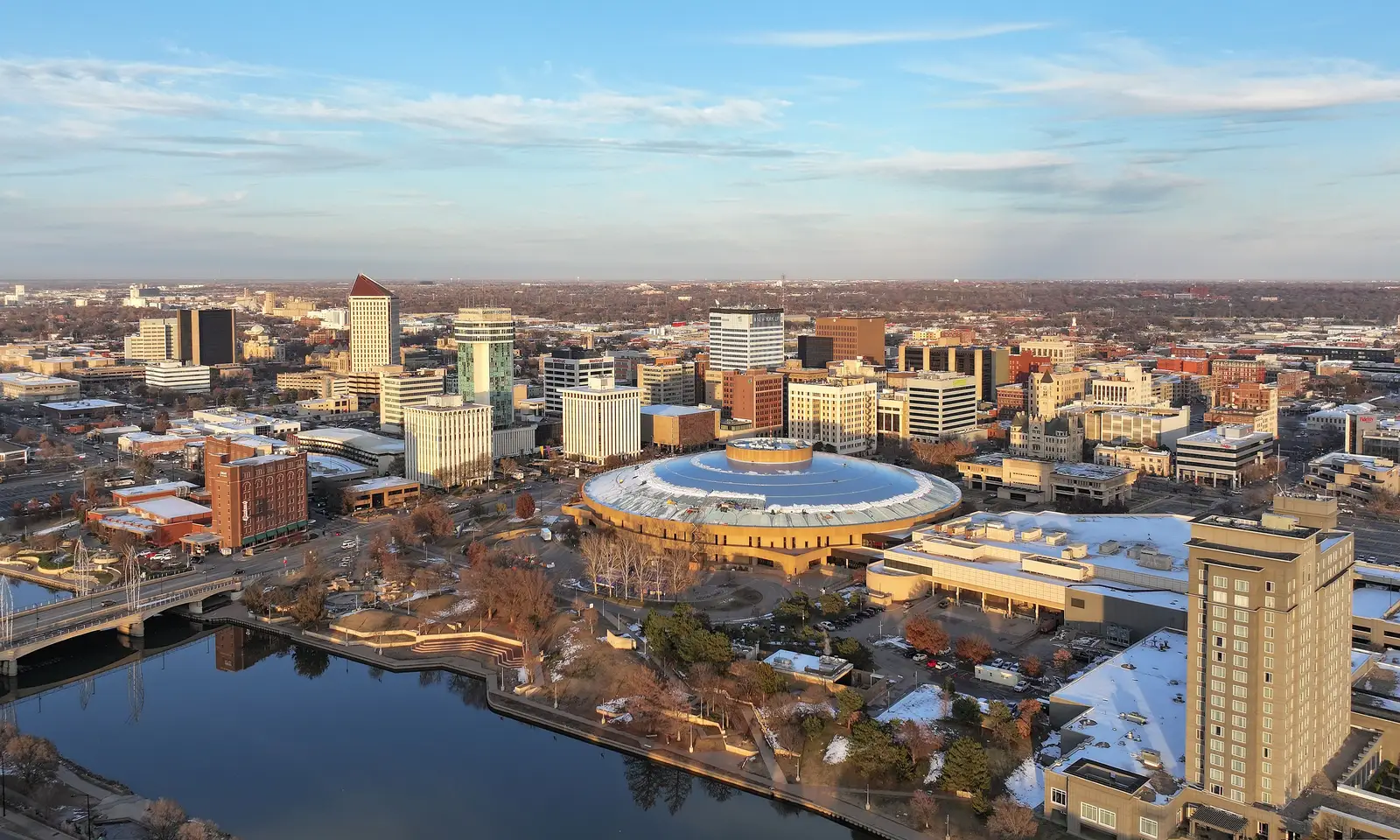 Downtown Wichita, Kansas skyline at golden hour, viewed across the Arkansas River