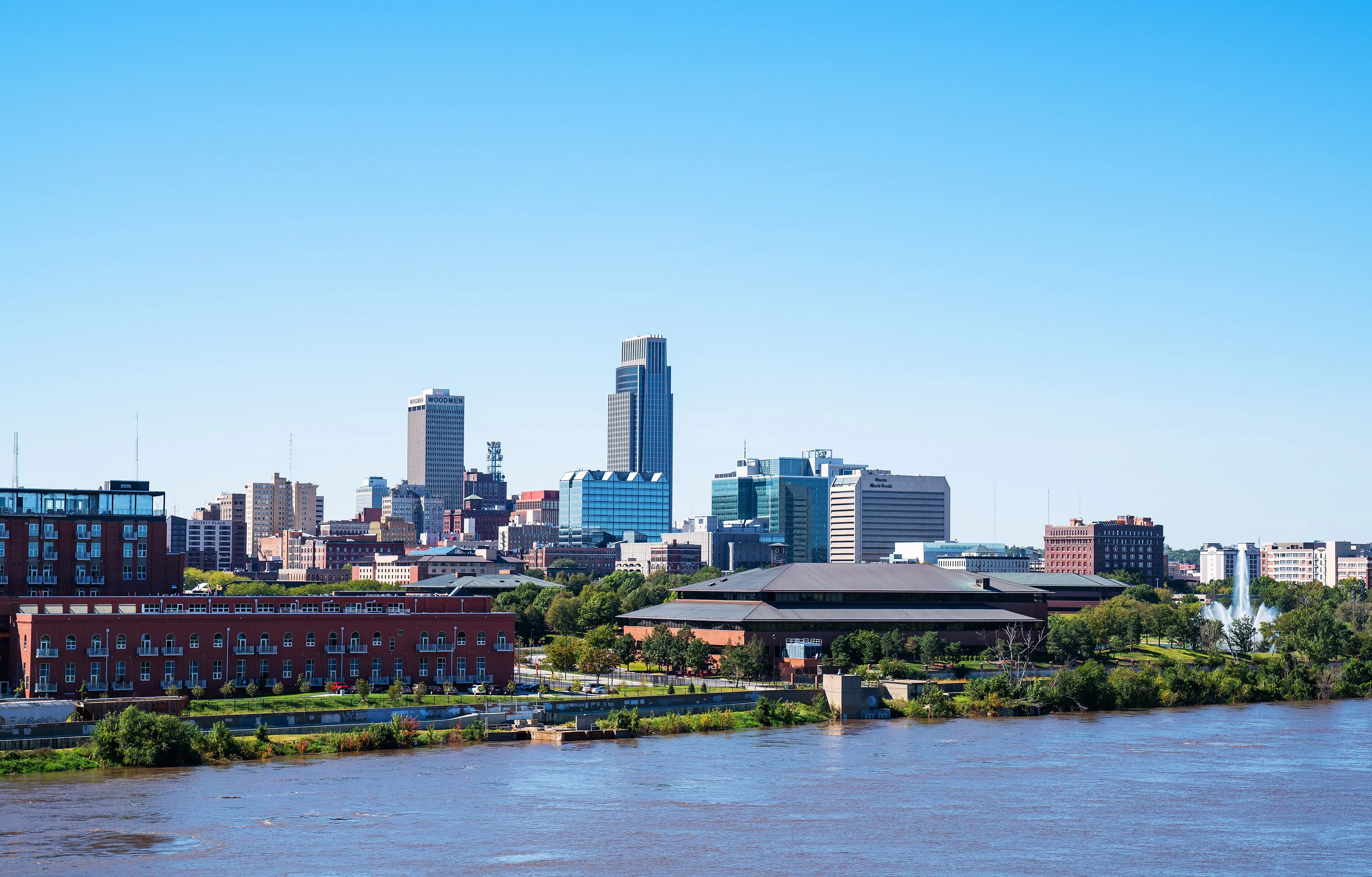 Downtown Omaha, Nebraska skyline viewed across the Missouri River, with high-rise buildings under a clear sky