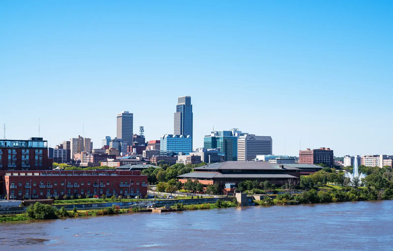 Downtown Omaha, Nebraska skyline viewed across the Missouri River, with high-rise buildings under a clear sky