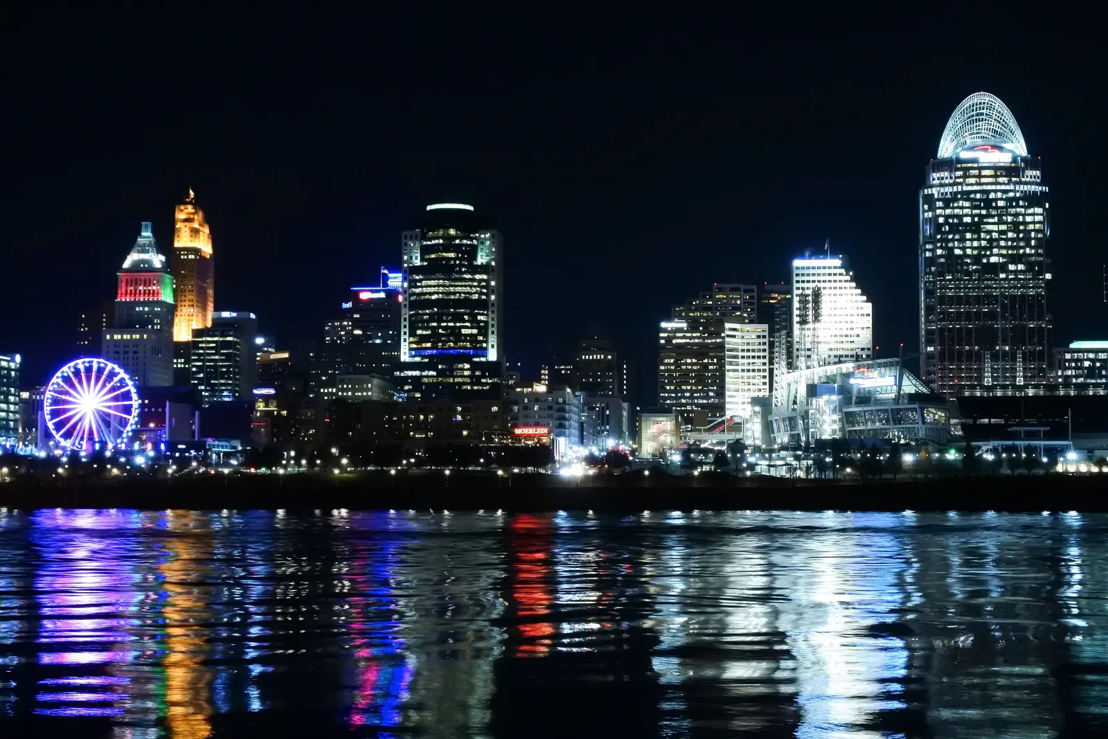 Downtown Cincinnati, Ohio skyline illuminated at blue hour, viewed across the Ohio River