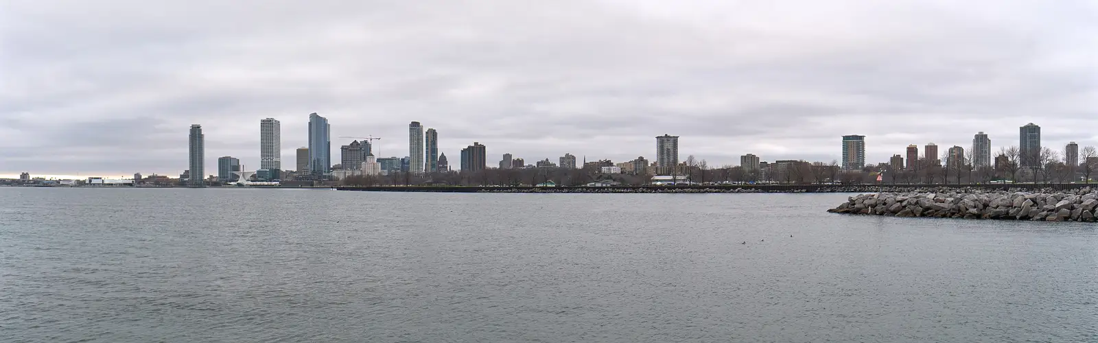 A wide panoramic view of the Milwaukee downtown skyline seen across Lake Michigan at golden-hour light, Wisconsin