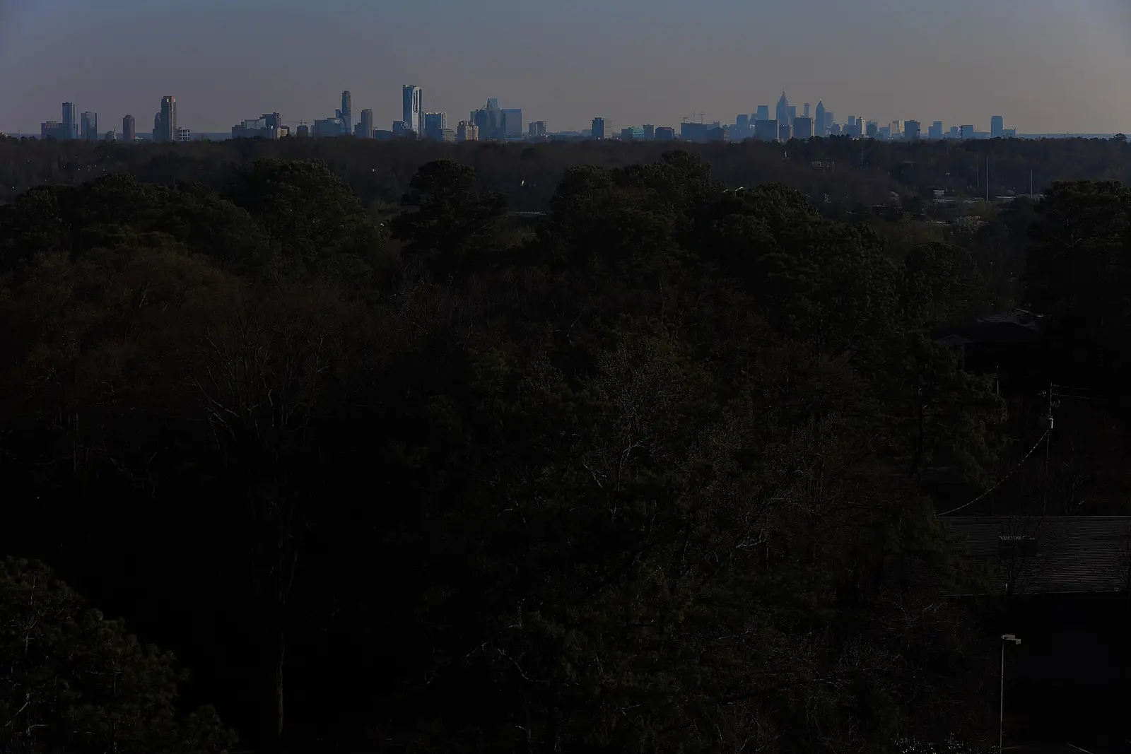 The Atlanta skyline — Buckhead, Midtown, and Downtown towers of Fulton County, Georgia rising above the tree canopy