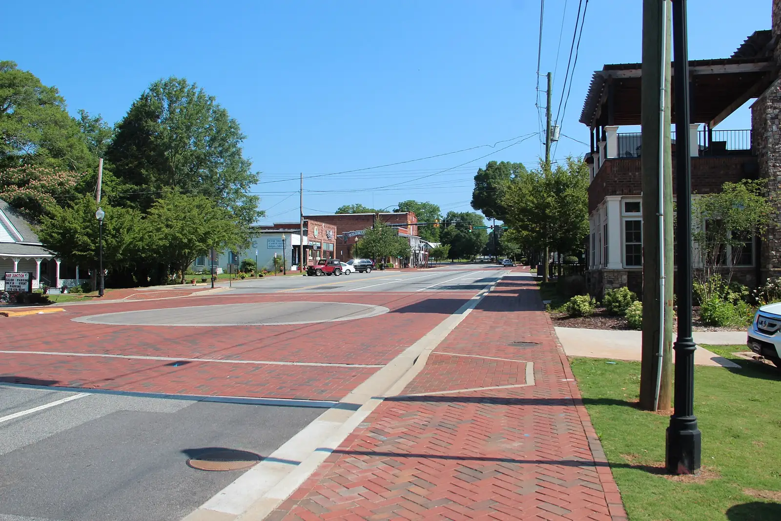 The historic brick storefronts and pedestrian plaza of downtown Kennesaw, Georgia, under a clear sky