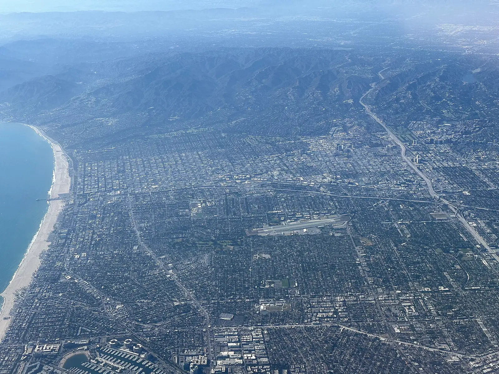 Aerial view of Santa Monica, California — coastline, pier, and mountains