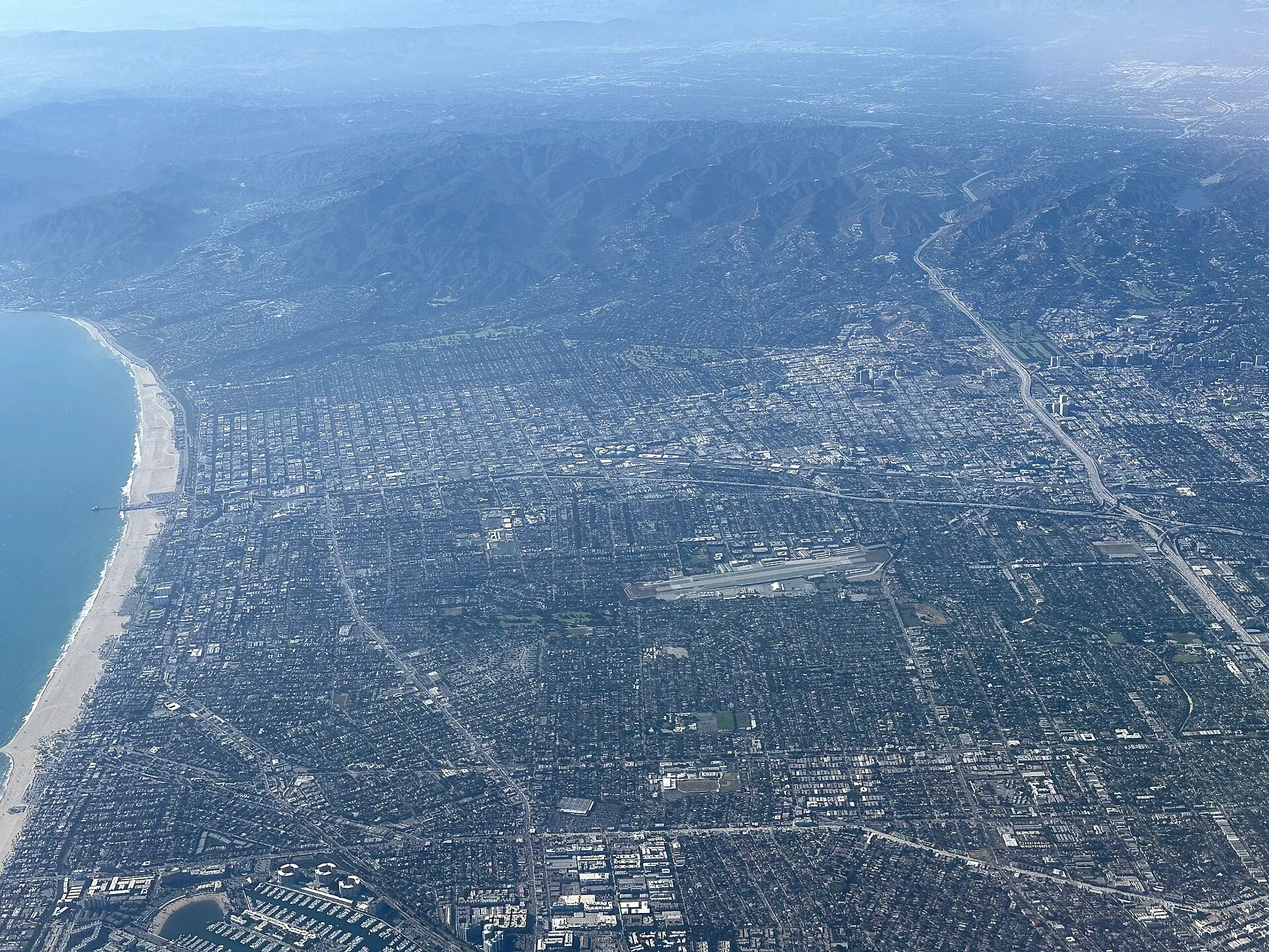 Aerial view of Santa Monica, California — coastline, pier, and mountains