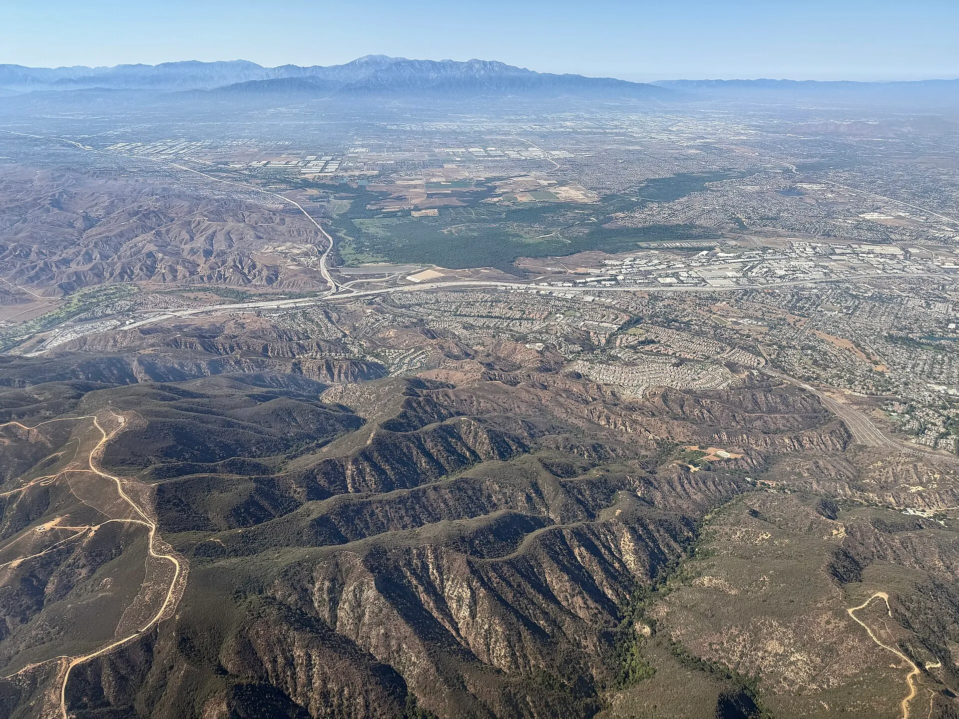 Aerial view of Corona, California, with residential neighborhoods extending toward the Santa Ana Mountains