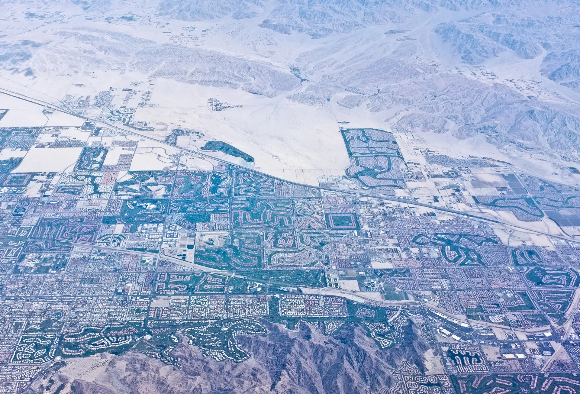 Aerial view of Palm Desert, California, with golf courses and country-club communities across the Coachella Valley desert floor