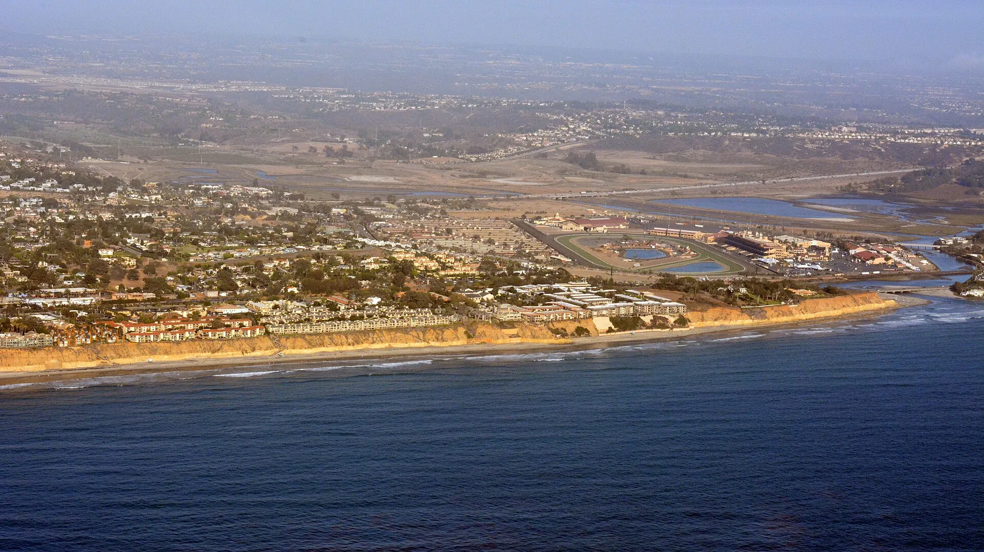 Aerial view of the Del Mar, California coastline, with beach, sea-cliff bluffs, and homes above the Pacific